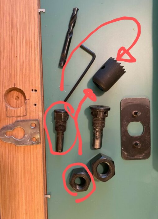 Verktyg och delar på bord, markerade med röd krita för att illustrera samband eller steg i process.