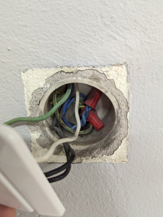 Öppen eldosabox med exponerade elektriska kablar och skarvklämmor, väntar på installation eller reparation.