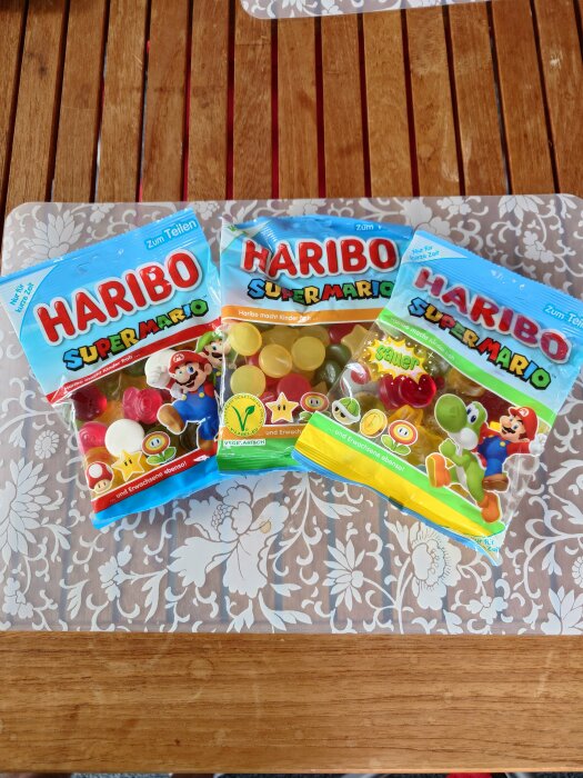 Tre förpackningar Haribo Super Mario-godis på mönstrad bakgrund.