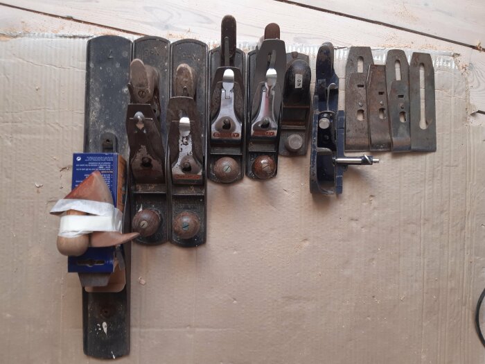 Samling gamla och använda hyvlar upphängda på en verktygstavla, träslöjd eller hantverksmiljö.