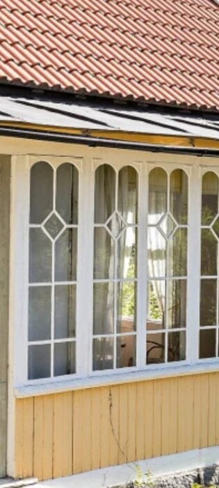 Tegelpannat tak, fönsterrad, vita spröjsade glas, gul trävägg, traditionell, arkitektonisk detalj, hemtrevlig, ljusinsläpp.