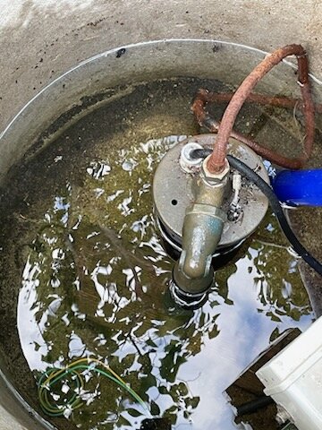 En brunnen med vatten, en pumpmekanism, rör och kablar, behöver troligen underhåll eller reparation.