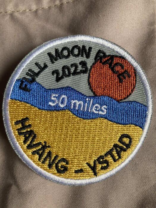 Broderad tygmärke; "Full Moon Run 2023, 50 miles", måne, vatten, sand; evenemang, uthållighetslöpning, Helsingborg-Ystad.