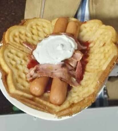Våffla formad som hjärta med korvar, grädde, bacon och röd sås. serving, udda måltid.