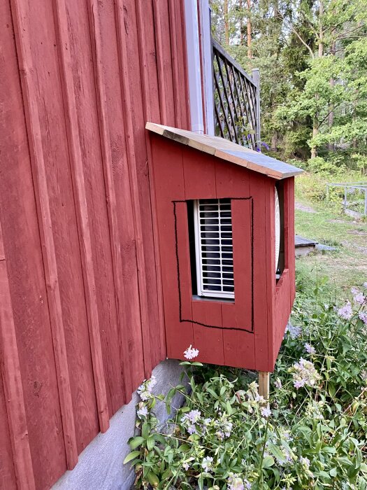 Röd stuga, fönsterlucka, grönska, sommarkväll, traditionell svensk arkitektur, trädgård, pittoresk, lantlig charm.