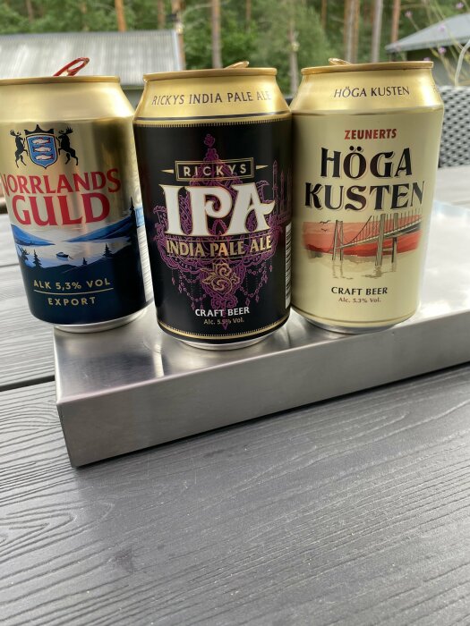 Tre ölburkar på en bänk: Norrlands Guld, Rickys IPA och Höga Kusten.