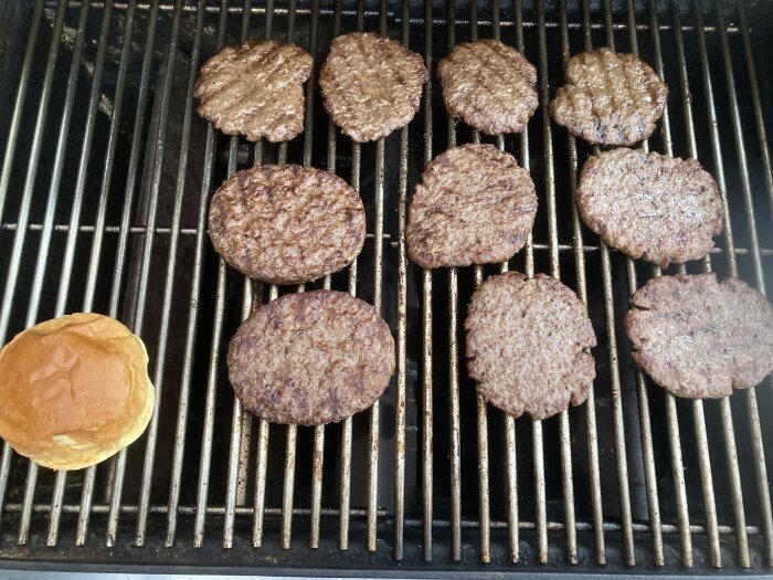 Hamburgare grillas på grillen, en bulle, matlagning utomhus, nio biffar, rostade mönster, sommar, BBQ.