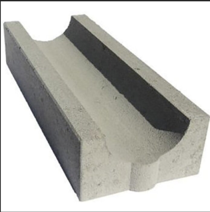 Ett grått betongelement med U-formad profil, troligen används för konstruktion eller avrinning.