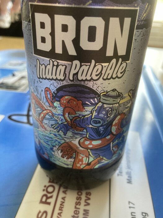 En ölburk med texten "BRON India Pale Ale" och en färgglad, konstnärlig design med ryggradslösa havsdjur.