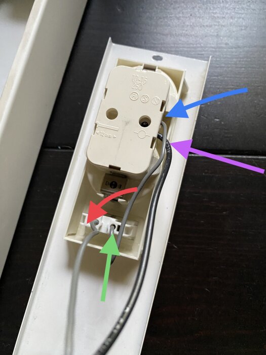 Öppen eluttaginstallation med synliga kablar och pilmarkeringar som antyder instruktioner eller anmärkningar.