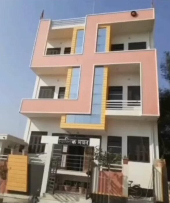 Modern byggnad, ovanlig 'E'-formad arkitektur, beige och gult färgschema, balkonger, bostadshus, klar himmel.