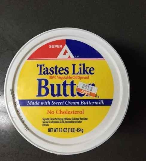 Rund behållare med text "Tastes Like Butt", "Made with Sweet Cream Buttermilk", "No Cholesterol", skämtsam design.