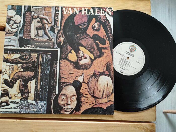 Vinylskiva och omslag med konstverk, Van Halen, "Fair Warning", träbakgrund.