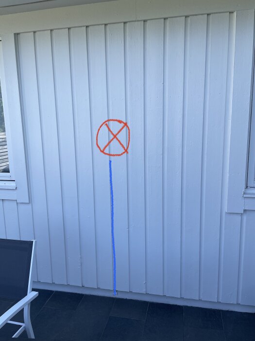 Vit vägg med röd och blå sprayfärg, förbjuden symbol, samtida gatukonst eller vandalism.