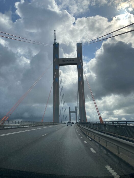 Tjörnbron i Sverige med bilar, dramatisk himmel, stora moln, kablar, väg.