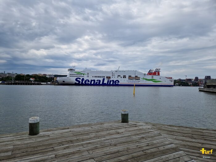 Ett stort fartyg med texten "Stena Line" ligger vid kaj, molnigt väder, träbrygga i förgrunden.