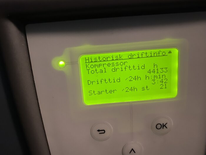 LCD-display med text, knappar under, information om kompressordrifttider, grönt sken.