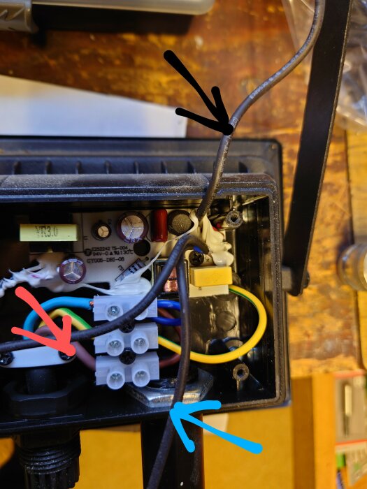 Öppen elektrisk låda med sladdar, terminalblock, och komponenter, potentiell säkerhetsrisk, behov av reparation.