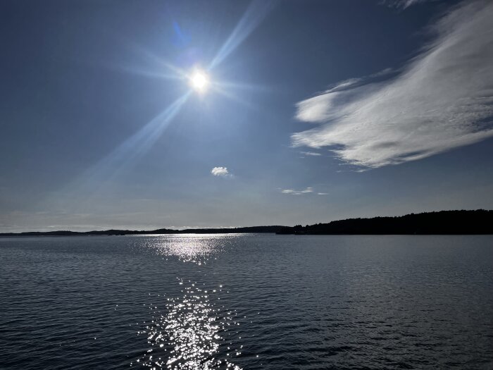 Solig himmel, glittrande hav, molnstreck, lugnt, dagtid, naturskön utsikt.