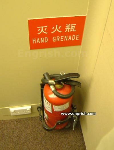 Brandvägg med skylt felstavad som "HAND GRENADE" istället för "HAND GRENADE EXTINGUISHER." Humoristisk översättningsmiss.