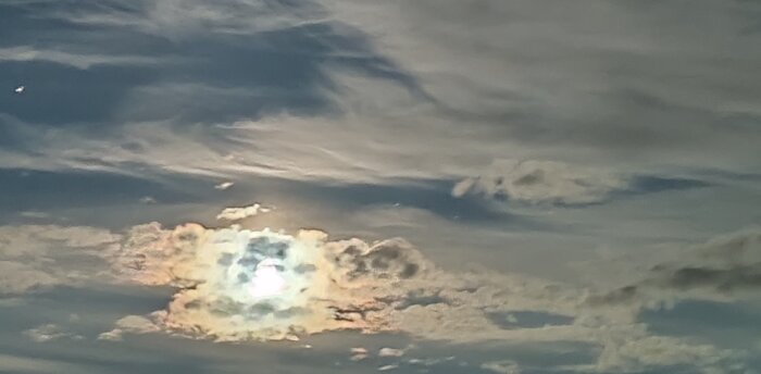 Dramatisk himmel med solen bakom moln, som skapar en strålande ljuseffekt.