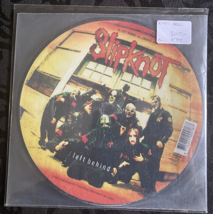 Slipknot-bandmedlemmar i masker, musikalbumomslag, "Left Behind," prislapp märkt, CD-fodral.