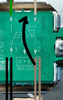 Grön elektronisk komponent med symboler, skruv, och en överstrukning gjord med en svart markör.