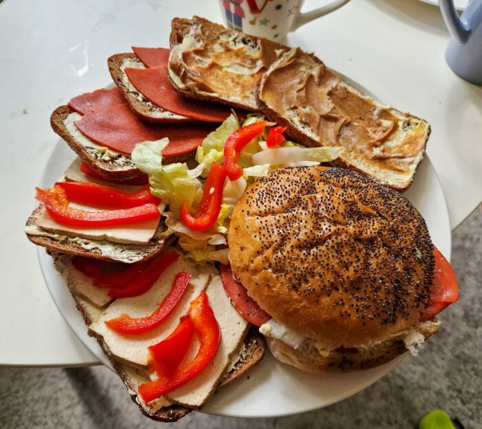 Mackor med skinka, kål, ost, paprika och smör på tallrik bredvid muggar.