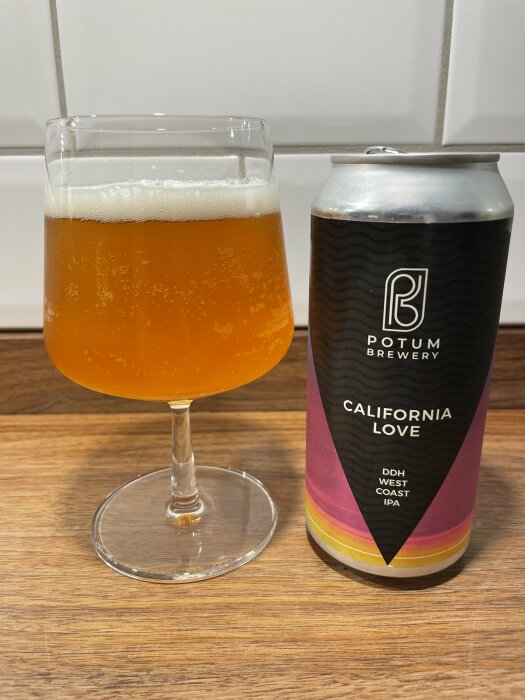 Ett glas med öl bredvid en ölburk på träyta. "California Love" DDH West Coast IPA från Potum Brewery.