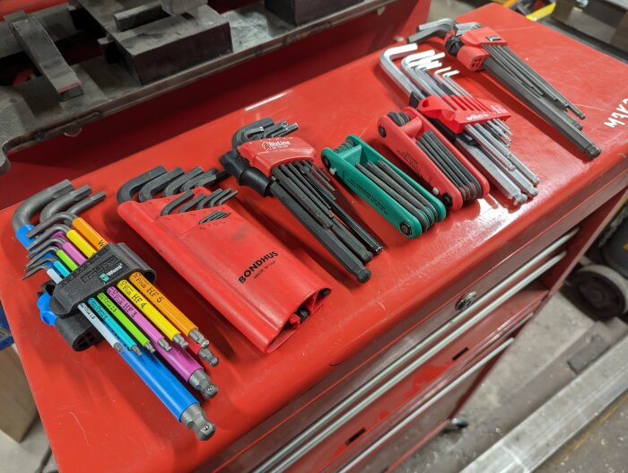Uppsättning av insexnycklar i olika storlekar och färger på en verktygsbänk.