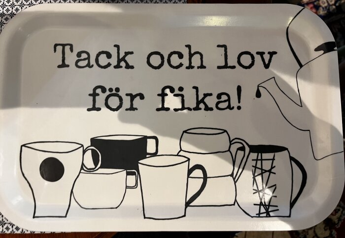 Bricka med text "Tack och lov för fika" och illustrationer av kaffekoppar.