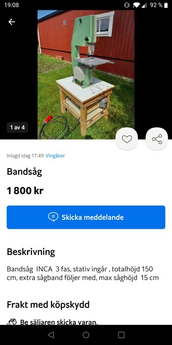 Bandsåg till salu, utomhus framför röd byggnad, på trästativ, inkluderar extra sågband, prissatt 1800 kr.