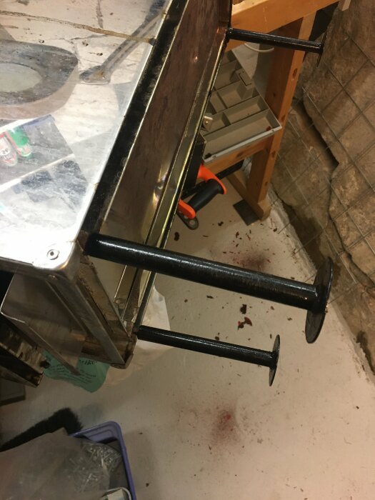 En rörpress på ett stökigt verkstadsgolv med verktyg och rörligt material.