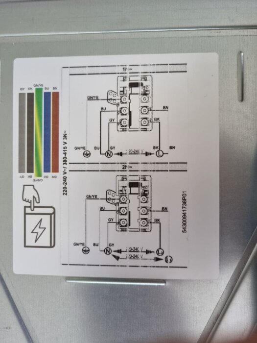 Elektrisk schematisk illustration på etikett; symboler för anslutningar, färger, spänningar. Bakgrund av metallisk yta.