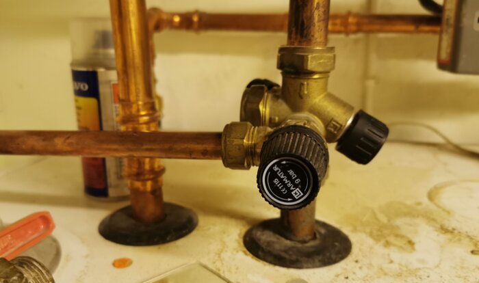 Värmeledningar med ventiler och inställningsratt, smutsiga och använda, underhåll krävs, inomhus VVS-setup.