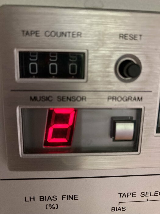 Kassettbandräknare och musiksensor på äldre ljudutrustning. Digital display visar nummer "3". Röd LED-belysning.