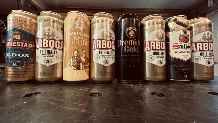 Samling ölburkar på bord, olika märken och sorter, retro och moderna designs.