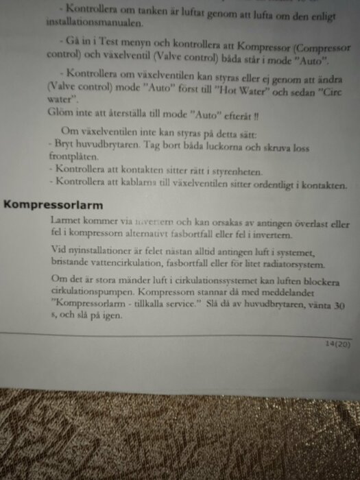 Instruktionsblad på svenska, teknisk vägledning, svart text på vitt papper, otydligt fotograferat, förgrund texturerat tyg.