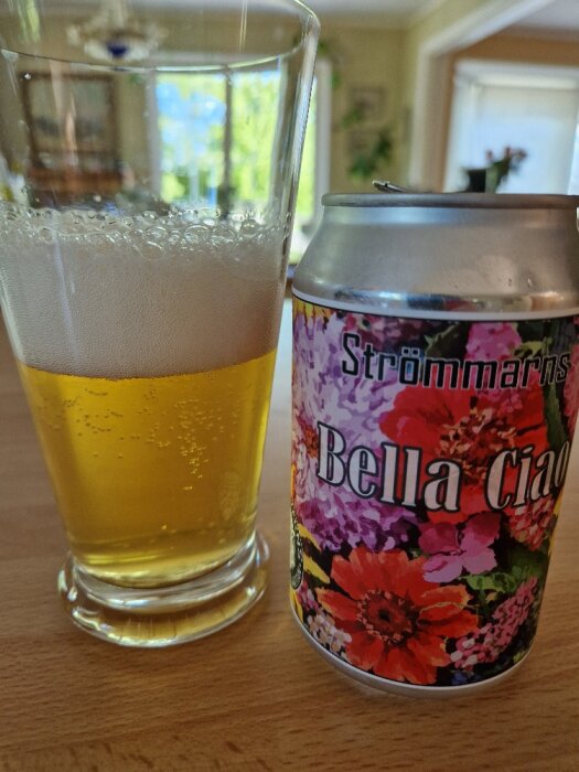 Ett glas med öl bredvid en färgglad burk märkt "Strömmarns Bella Ciao".