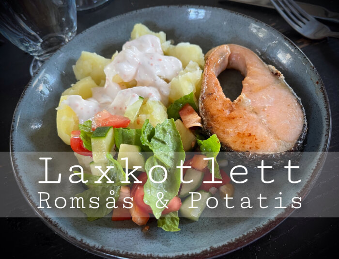 Tallrik med laxkotlett, romsås, potatis och sallad. Maträtt serverad, redo för måltid.