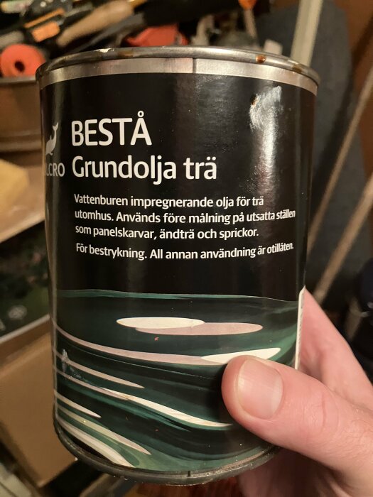 Burk med BESTÅ Grundolja trä, vattenburen olja för trä, hålls i hand. Används före målning utomhus.