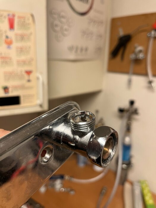 Metallisk, genomskinlig rökstycke, förgrundsfokus, suddig bakgrund med verktyg och instruktioner.