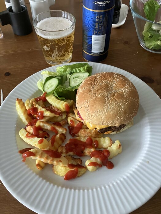 Ostburgare med pommes frites och ketchup, öl i glas, salladsblad och gurka, inomhusmåltid.