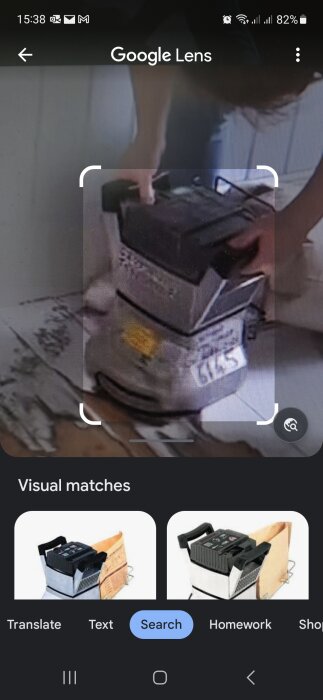 En person håller i en batteridriven verktygslåda, Google Lens-gränssnitt, sökförslag på skärmen.