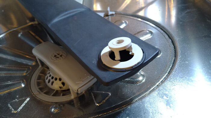 Gaskokplatta med borttagen brännare och lock, visar interna delar och smuts.