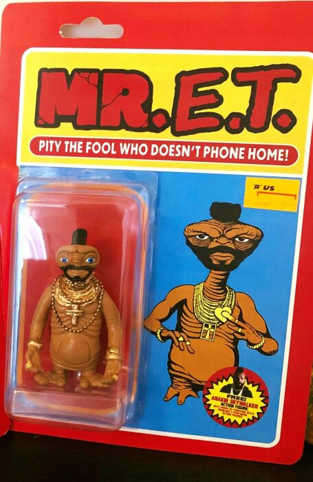 Satirisk actionfigur, parodi mellan E.T. och Mr. T, paketerad, leksak, "Pity the fool"-citat, humoristisk, samlarobjekt.