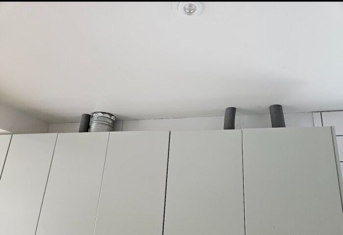 Vitrum med skåpluckor, tak och ventilationsrör. Enkel, minimalistisk, modern interiör.