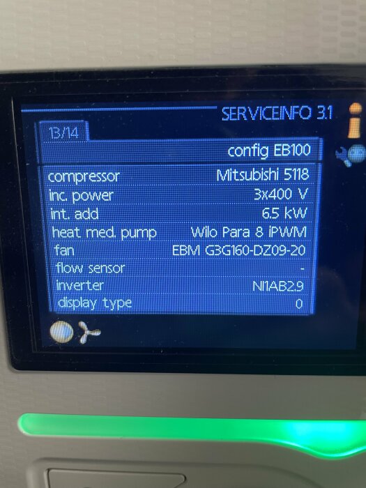 Digital display visar tekniska specifikationer, inklusive kompressor och fläktmodell, för en enhet eller system.