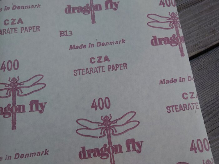 Papper med upprepande text och trollslände-bilder, "Made in Denmark", "dragon fly", "400", "CZA STEARATE PAPER".