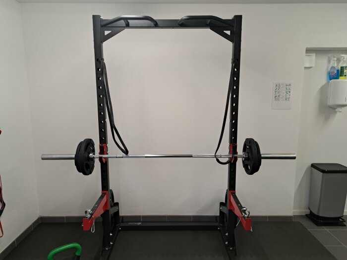 Squatrack med en skivstång och vikter i ett gym. Träningsutrustning för styrketräning.